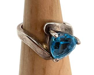 A trillion cut topaz sits at the center of this size 6 sterling silver ring. 5.61 gtw.