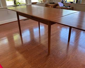 K67 - $300. MCM Teak Hidden Leaf Dining Table. Has some surface wear on top & legs. Overall sturdy. Measures 35" wide x 53" long x 29" tall. 2 leaves pull out and each adds 18"
