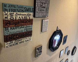Various wall art with sayings, mirror and metal art