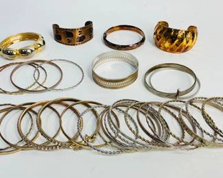 Over 15 bangle style bracelets in silver or gold tone, some with rhinestones, (1) copper cuff bracelet with bear paw design and more. See photos for sampling. Shipping-YES