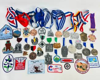 This lot includes an assorted collection of medals, patches, and pins celebrating various Colorado events and other local gatherings, notably the USAF Volksmarch and the Falcon Wanderers walks. Shipping-YES