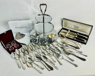 Dinner Necessities. (1) Imperial Knife Carving set in a box. (1) 3-tier dessert tray by Kromex, (1) cream and sugar set, (1) Cassiani Signature Collection Italian white porcelain plate with silver trim, (1) box with salt cellars with spoons in original box, numerous pieces of flatware by Prestige and WM Rogers. (1)mUmbra Zoola Elephant Ring Holder. Shipping-YES