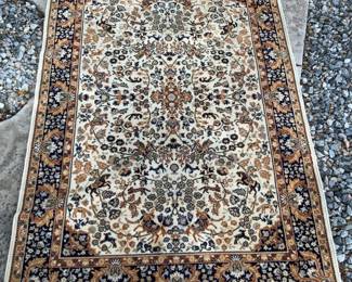 Oriental style area rug with gold, blue and cream coloring. Rug has a floral design border with a hunter and animal symbols. 67" x 101". Has some fraying on the edges, fringe is damaged in one area and a hole on one side. The purple/blue color has bled into the design in some areas. See photos for more details. Shipping-NO