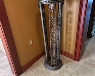 Decorative Pedestal Table – Elegant round pedestal table with a detailed carved metal base featuring acanthus leaf and ram’s head motifs. Dark top with beaded edge trim. Perfect for displaying art, plants, or a statement décor piece in a hallway, living room, or entry.