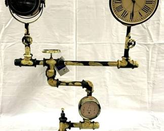 9500 - Industrial Style Floor Clock by Alma Artte 34.5 x 25 x 8 - lamp side is decorative only - glass front on clock is missing Made from old discarded piece of water pump - one side has a clock and the other side has a lamp. Consigned by wholesaler / distributor, untested, no warranties.
