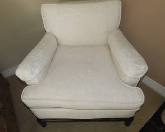 One of two matching off white armchairs.