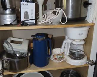 Mini food processor, electric can opener, slow cooker, hand mixer, smoothie stick, electric carving knife, coffee machine, stainless mixing bowls.