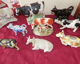 Collection of cows, Delft, Lladro, Germany, Japan, England, porcelain, bisque some are milk jugs some are ornaments.