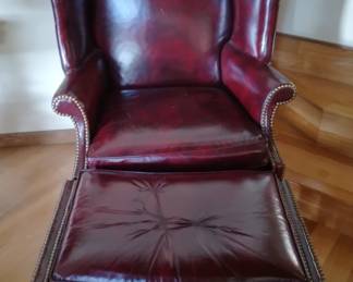 Burgundy leather wingback chair with ottoman. L- 32 in.     W- 54 in. (Includes foot stool)    H-  40 in. ( chair ). 18 in. (foot stool)