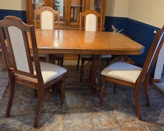 Wood dining table with four chairs and matching hutch