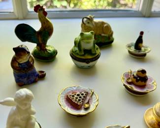 Close-up of the collection of hand-painted Limoges petit mains boxes. Many garden, animal, and food themed.