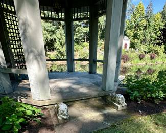 A gazebo in the garden with pair of white Carrara marble  recumbent lions