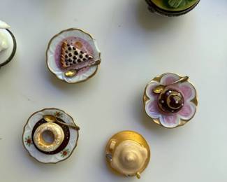 Close-up of the collection of hand-painted Limoges petit mains boxes. Many garden, animal, and food themed.