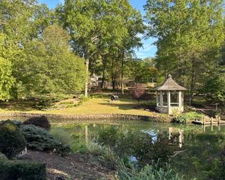 View of one of the ponds in the property with "Trouble Essential"  bronze by Sophia Vari (1940-2023) in the distance. 