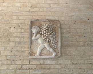 'Grape Harvesting Putto' high relief plaque imitating Vicenza stone, by Carlo Marchiori, Italy (b1937).