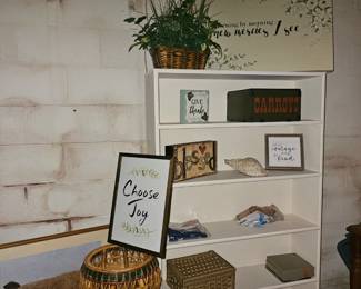 Bookcase, wicker plant stand, artwork 