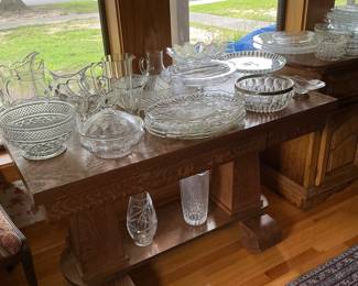 Beautiful glass and cut crystal serving pieces, sitting on top of a tiger Oak library table