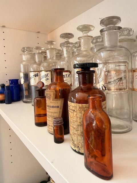 Antique apothecary glass bottles, amber and clear medicine jars, vintage pharmacist decor