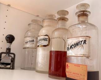 Antique apothecary bottles labeled Aconitr., Tartaric Acid and red liquid, vintage pharmacy glass collection
