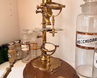 Antique brass laboratory stand on ornate base, vintage apothecary lab equipment decor