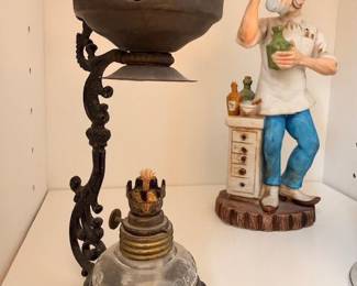 Vintage cast iron ornate stand with metal bowl, ceramic figurine pharmacist character, pharmacy collectibles