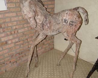 The image displays a sculpture of a young horse, likely a foal, created by artist Siri Hollander