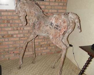The image displays a sculpture of a young horse, likely a foal, created by artist Siri Hollander