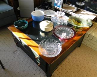 Glass topped table to show off your collections, and on top of that table we have a collection of serving pieces, bowl and the the like