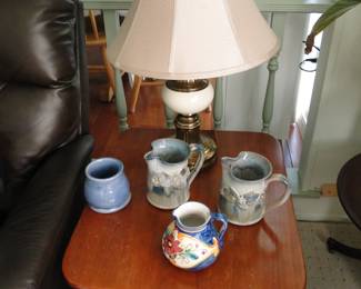 A trio of pitchers, a lamp, and a cup