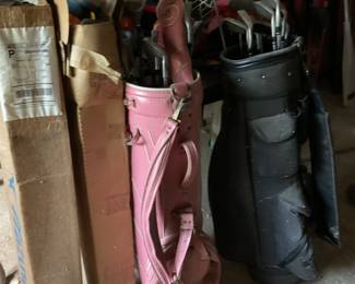 Golf clubs and golf bags. Entry hall table with glass, Several fans and large outdoor heater lamp.