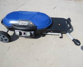 Lot 314. Coleman portable rolling grill. Uses one pound propane bottles.