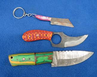 Lot 228. Three fixed-blade knives with leather sheaths, two are Damascus knives