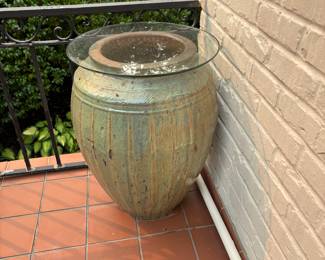 Ceramic glazed pot with glass for use as a table.