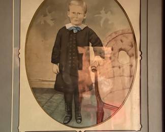 Antique portrait of boy next to chair 