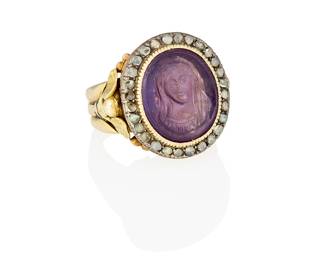 82
An 18K Gold, Amethyst and Diamond Ring
Centering a carved 'Mother Mary' amethyst cabochon, encircled by rose-cut diamonds set amongst flower and cross etchings, accented by two winged angels on the shank, with original Italian box

Size: 11 3/4
27.8 grams gross
Estimate: $2,000 - $3,000