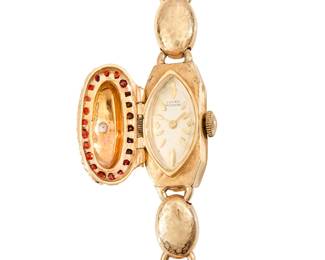 275
Lucien Piccard: A 14K Gold, Garnet and Diamond Surprise Watch
Dial: 8.50 mm, marquise shaped with baton hour markers, encircled by round garnets
Case: 12.00 mm
Case number: c 0768
Closure: featuring a textured oval gold link bracelet with jewelry clasp
Signed: dial and clasp

Inner circumference: 7 - 7 1/2 in.
26.0 grams gross
Estimate: $1,500 - $2,500