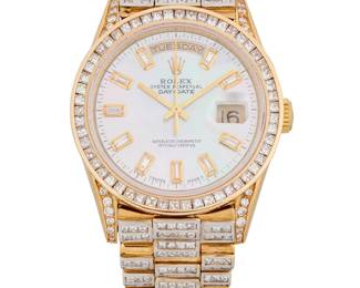 302
Rolex: An 18K Gold and Mother-of-Pearl Watch
Dial: 30.00 mm, mother-of-pearl dial with baguette diamond hour markers, with after-market diamonds on the bezel and bracelet weighing approximately 9.52 carats
Model: day-date
Case: 40.00 mm
Case number: L744790
Closure: bi-color gold links finished with a deployment clasp
Signed: dial and clasp, including three additional links

Inner circumference: 7 in.
138.7 grams gross
Estimate: $8,000 - $12,000