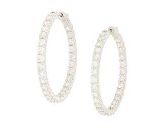 72
A Pair of 14K White Gold and Diamond Hoop Earrings
Featuring round diamonds weighing approximately 7.10 carats set half in front and half inside the hoop
2 pieces

Measures: 1 1/2 in.
14.2 grams gross
Estimate: $3,500 - $4,500
