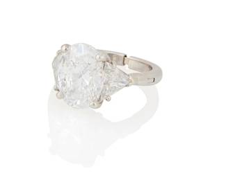 210
A Platinum and Diamond Ring
Centering an oval diamond weighing 5.03 carats, accented by two triangular-cut diamonds weighing approximately 2.22 carats total

Size: 6 (arthritic shank)
7.8 grams gross

Accompanied by a GIA Report numbered #6233635049, dated July 15, 2025, stating the diamond as Natural with a color grade of D and a clarity grade of SI1, no fluorescence.
Estimate: $100,000 - $150,000