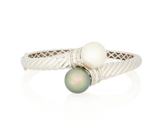 153
A 14K White Gold, Cultured Pearl and Diamond Bangle
Of a hinged design featuring a bypass motif of a white and black cultured pearl accented by round and baguette diamonds

Inner circumference: 6 3/4 in.
26.2 grams gross
Estimate: $2,000 - $3,000