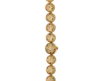 276
Piaget: A 14K Gold and Gem-Set Surprise Watch
Dial: 13.70 mm, round with Arabic hour markers
Case: 17.40 mm
Case number: 21450
Closure: featuring a domed gold link bracelet set with star motifs with chrysoprase, ruby, sapphire and seed pearls
Signed: case and dial, with original box

Inner circumference: 6 1/2 in.
46.2 grams gross
Estimate: $3,500 - $5,500