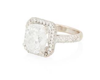 33
An 18K White Gold and Diamond Ring
Centering cushion modified brilliant-cut diamond weighing 5.04 carats accented by round diamonds on the mount and half shank

Size: 5
8.3 grams gross

Accompanied by a GIA Report numbered #2235579587, dated May 07, 2025, stating the diamond as Natural with a color grade of G and a clarity grade of VS1, no fluorescence.
Estimate: $60,000 - $80,000