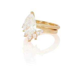 113
A 14K Gold and Diamond Ring Set
Centering a pear brilliant-cut diamond weighing 2.21 carats, accented by a curve band set with graduated pear-shaped and round diamonds
2 pieces

Size: 5 1/2
4.9 grams gross

Accompanied by a GIA Report numbered #1232571816, dated April 28, 2025, stating the diamond as Natural with a color grade of H and a clarity grade of SI2, faint fluorescence.
Estimate: $5,500 - $7,500