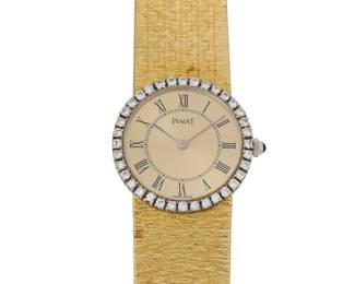 277
Piaget: An 18K Gold and Diamond Watch
Dial: 19.65 mm, round gold dial with Roman numeral hour markers encircled by round diamonds weighing approximately 0.64 carat
Case: 23.80 mm
Case number: 926A6, 305298
Closure: Woven gold strap with jewelry clasp
Signed: dial and clasp, with signed box

Inner circumference: 6 1/4 in.
61.8 grams gross
Estimate: $3,000 - $5,000