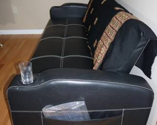Leather futon opens up to a full size bed.