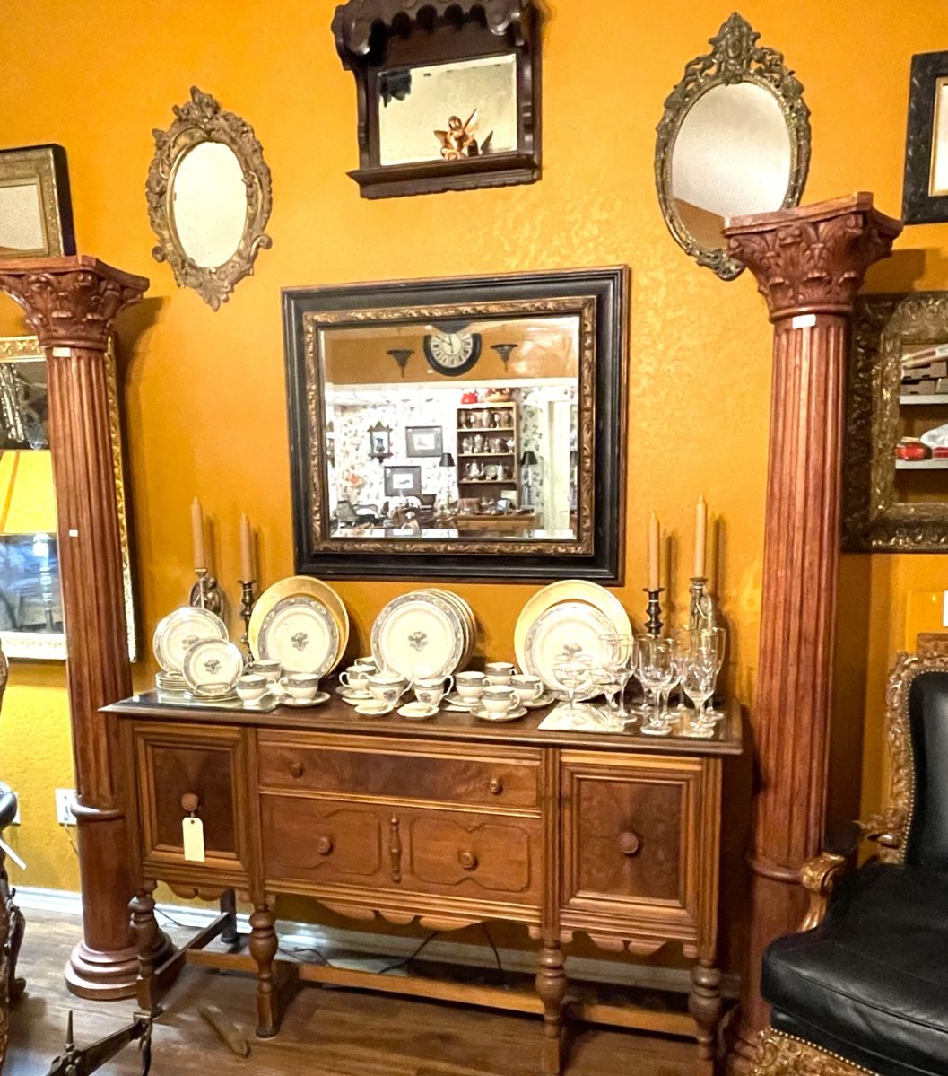 Beautiful old buffet, two decorative wooden columns, part of a large collection of mirrors, and Lenox china and Noritake crystal.