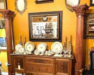 Beautiful old buffet, two decorative wooden columns, part of a large collection of mirrors, and Lenox china and Noritake crystal.