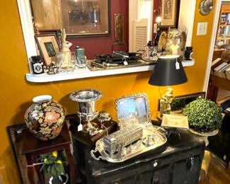 Nice collection of silverplate items sitting on a large old steamer trunk.