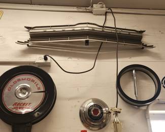 Top - Chrome grille piece (likely Oldsmobile Cutlass, late 1960s–early 1970s). Middle – Packard hubcap (mid-century, 1950s Packard).  Right – Chrome wheel trim rings