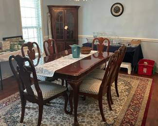 beautiful dining room suite with 2 leaves and 8 chairs, rug, lighted corner hutch